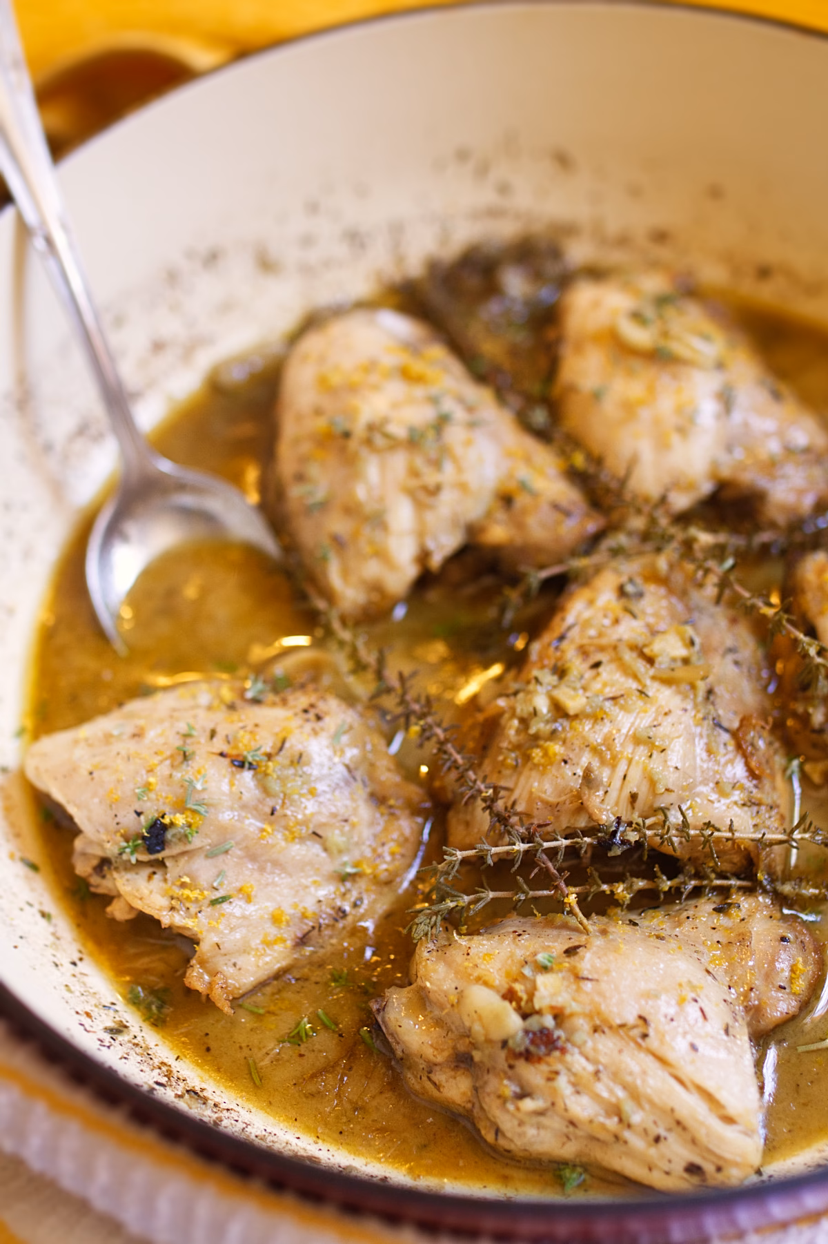 Spanish garlic lemon chicken in pan with garlic and herbs