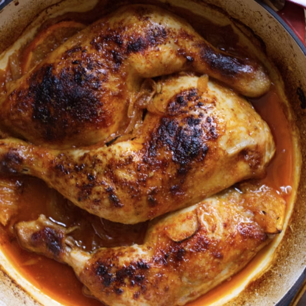 Chicken pieces cooked in vermouth in a pan.