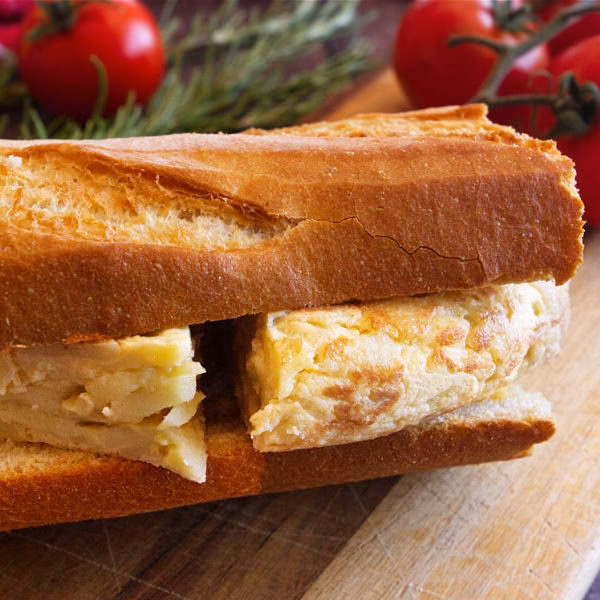 A sandwich with thick slices of tortilla in it on a chopping board.