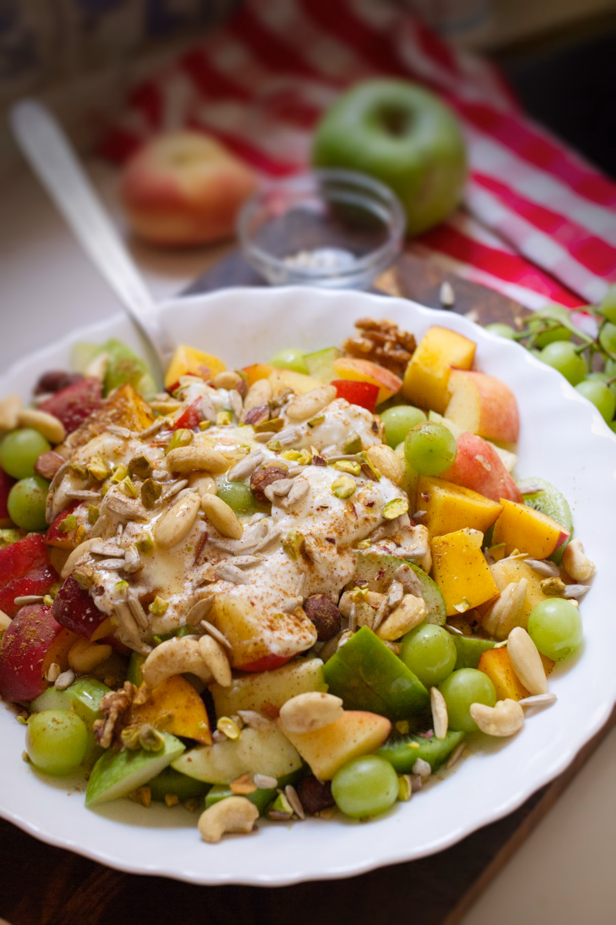 A bowl of freshly prepared Mediterranean fruit salad garnished with yogurt, nuts, and seeds