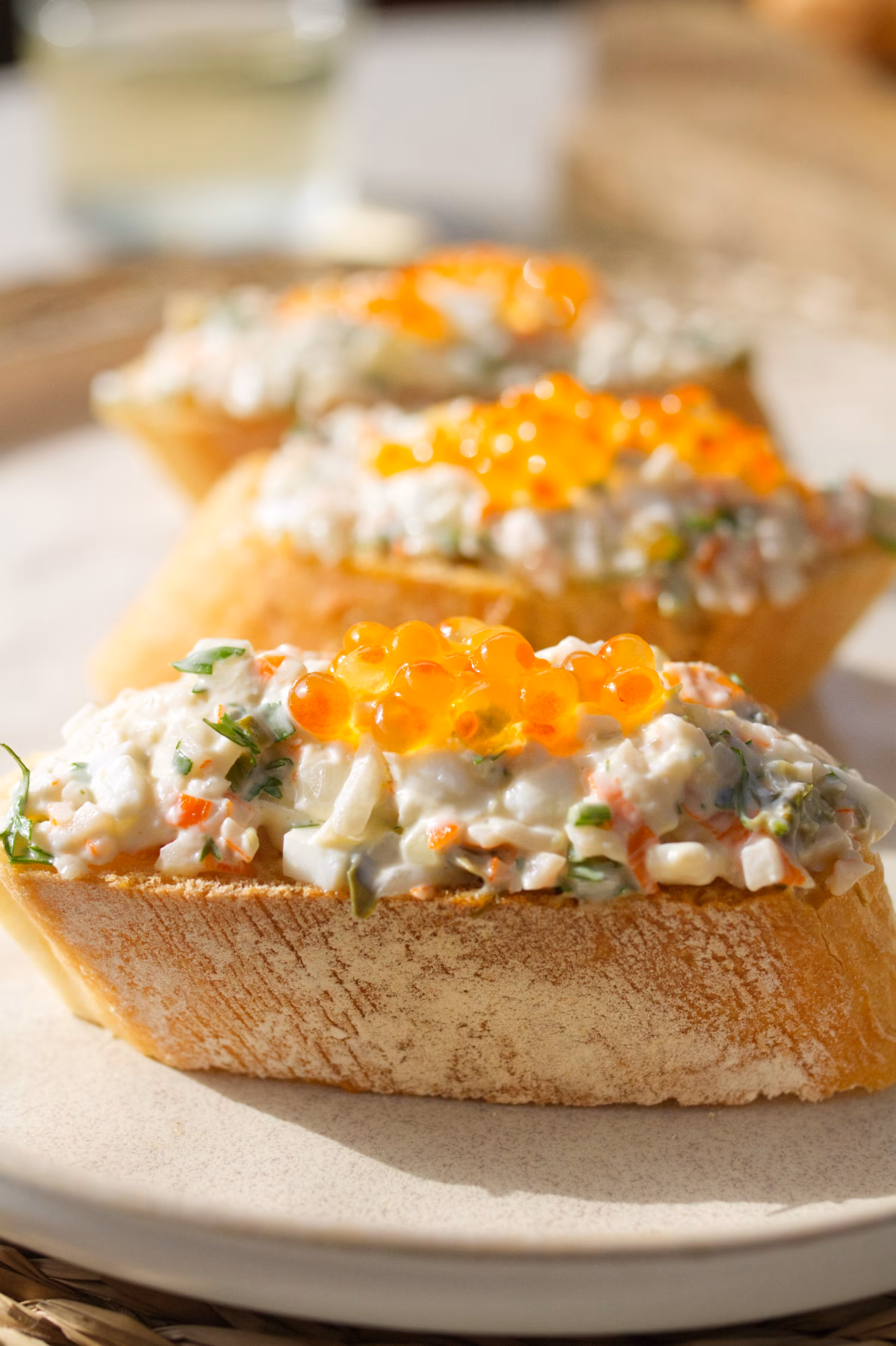 A person reaches in to grab a Txaka Pintxo on a plate