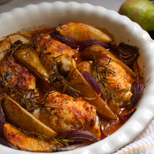 Baked Chicken with Spiced Pears-v2 - The Spanish Radish A large pan of baked Chicken thighs with Spiced pears and rosemary garnish