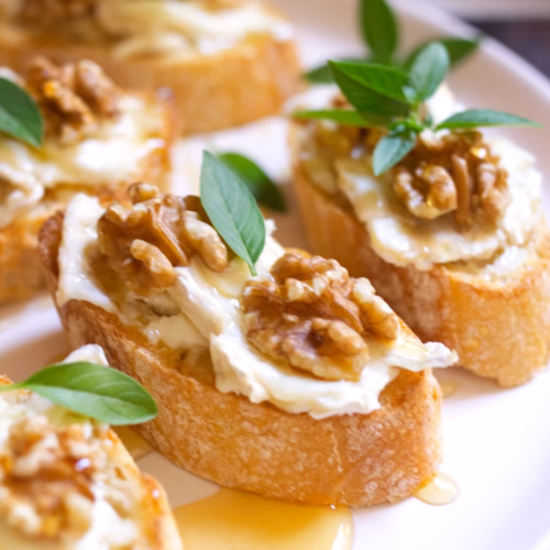 Goat Cheese Walnut Honey Pintxos-v1 - The Spanish Radish A platter of Goat cheese pintxos with walnuts and drizzled with honey