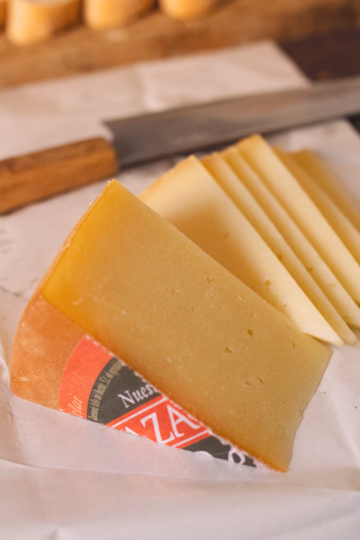 A wedge of Idiazabal cheese sits on a cheese board