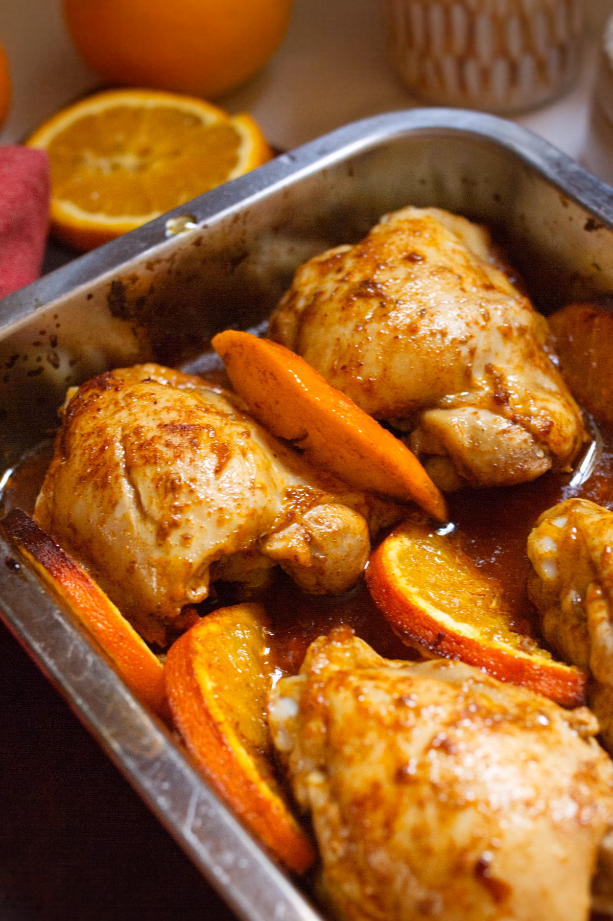 A pan of Spanish oven chicken with sliced orange rounds