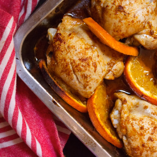 Spanish-Style Orange Chicken - The Spanish Radish A pan of Spanish oven chicken with sliced orange rounds