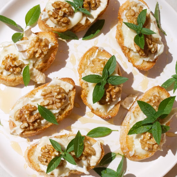 A platter of Goat cheese pintxos with walnuts and drizzled with honey