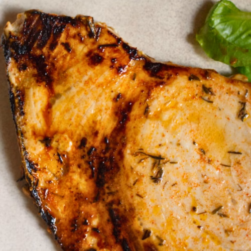 A large piece of marinated fish cooked with some salad
