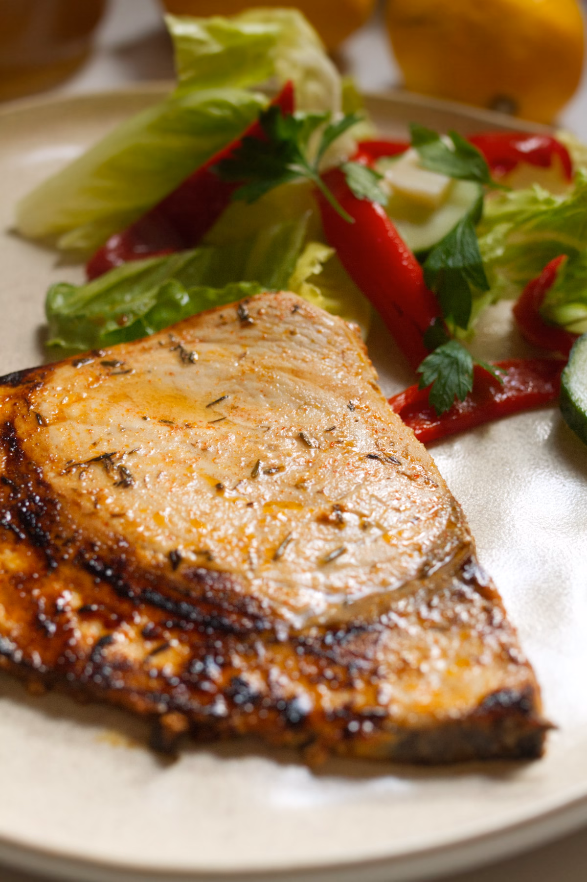 A large piece of marinated fish cooked with some salad