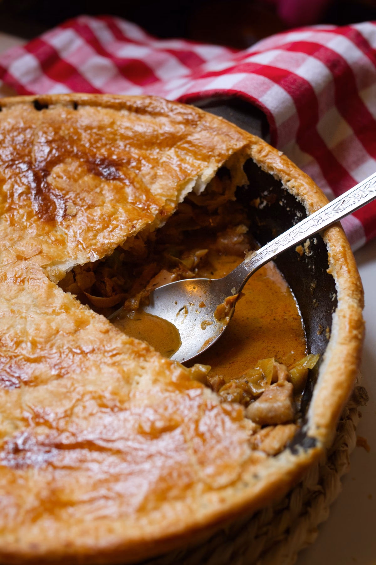 A large Spanish chicken and leek pie with a slice removed